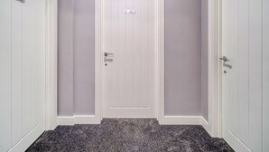 Un pasillo con dos puertas blancas, cada una con un número y un nombre.