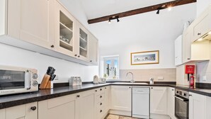 A kitchen with white cabinets, a microwave, a sink, and a dishwasher. - 2 bedroom accommodation in South Barrow, near Yeovil (South Barrow, near Yeovil)