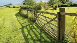 A rural landscape with a wooden gate, lush green grass, and trees. - 2 bedroom accommodation in South Barrow, near Yeovil (South Barrow, near Yeovil)
