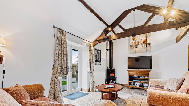 A living room with a fireplace, sofa, TV, and bookshelves. - 2 bedroom accommodation in South Barrow, near Yeovil (South Barrow, near Yeovil)