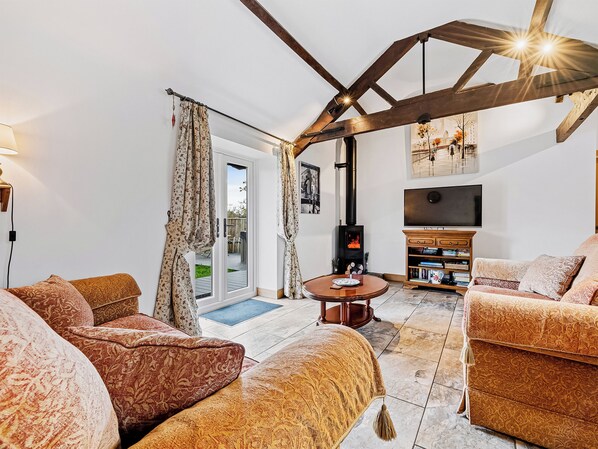A living room with a fireplace, sofa, TV, and bookshelves.