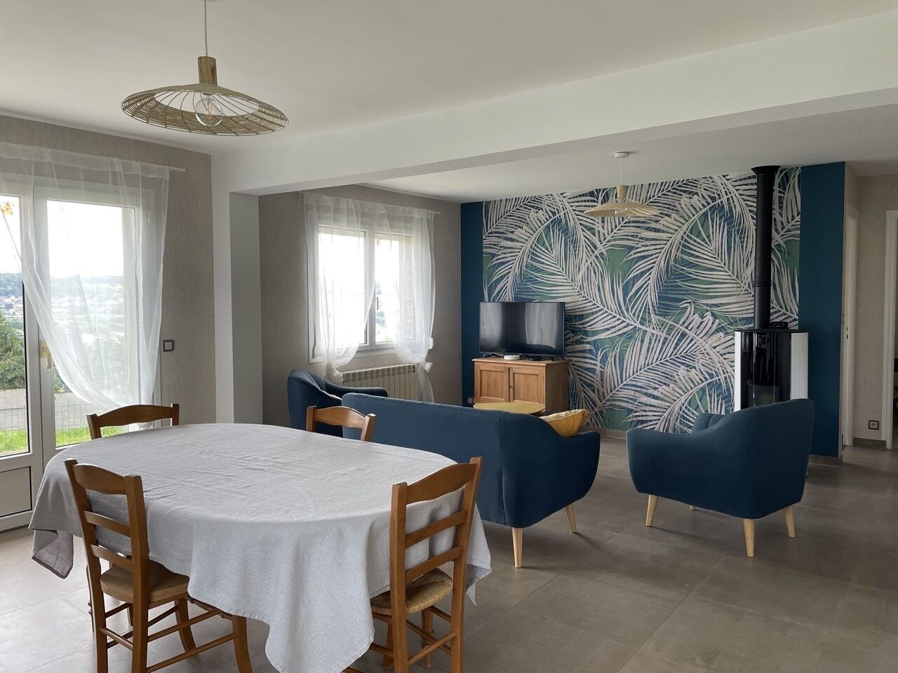 Un coin repas avec une table ronde, des chaises et un canapé bleu.