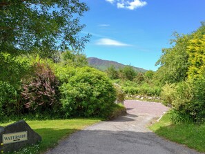 Un chemin de gravier mène à un panneau indiquant « BORD DE L’EAU ».