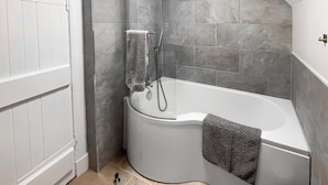A corner bathroom with a shower, a toilet, and a bathtub. - 2 bedroom accommodation in Girvan (Girvan)