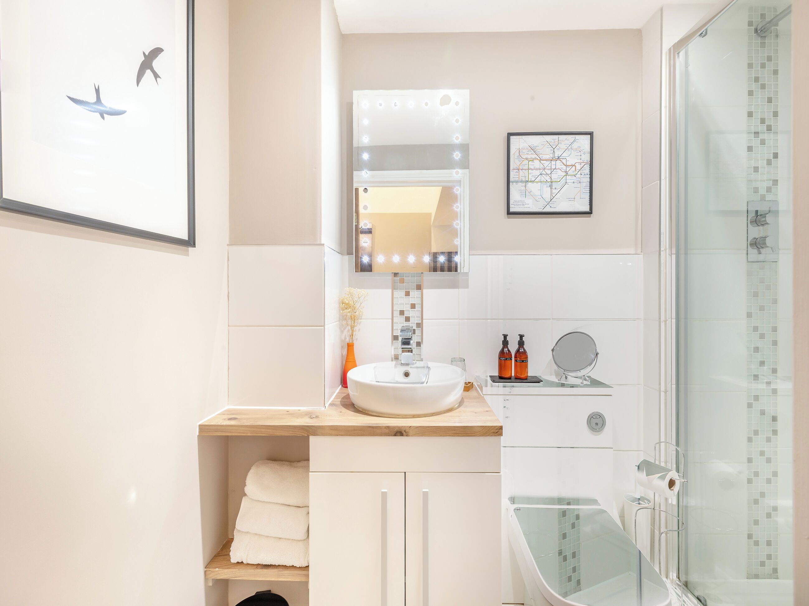 Ein modernes Badezimmer mit Waschtisch, Spiegel und Dusche.