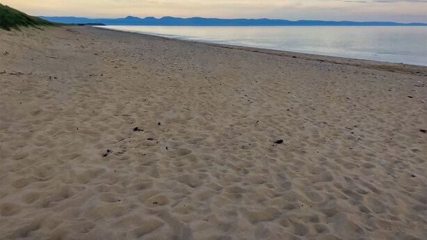 A sandy beach with a clear sky and distant mountains. - Converted barn set on a working farm with plenty of walks from the door. (Abererch, near Pwllheli)