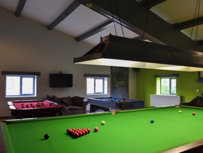 A pool table with balls, a dartboard, and a television on the wall. - 2 bedroom accommodation in Brandesburton, near Bridlington (Brandesburton, near Bridlington)