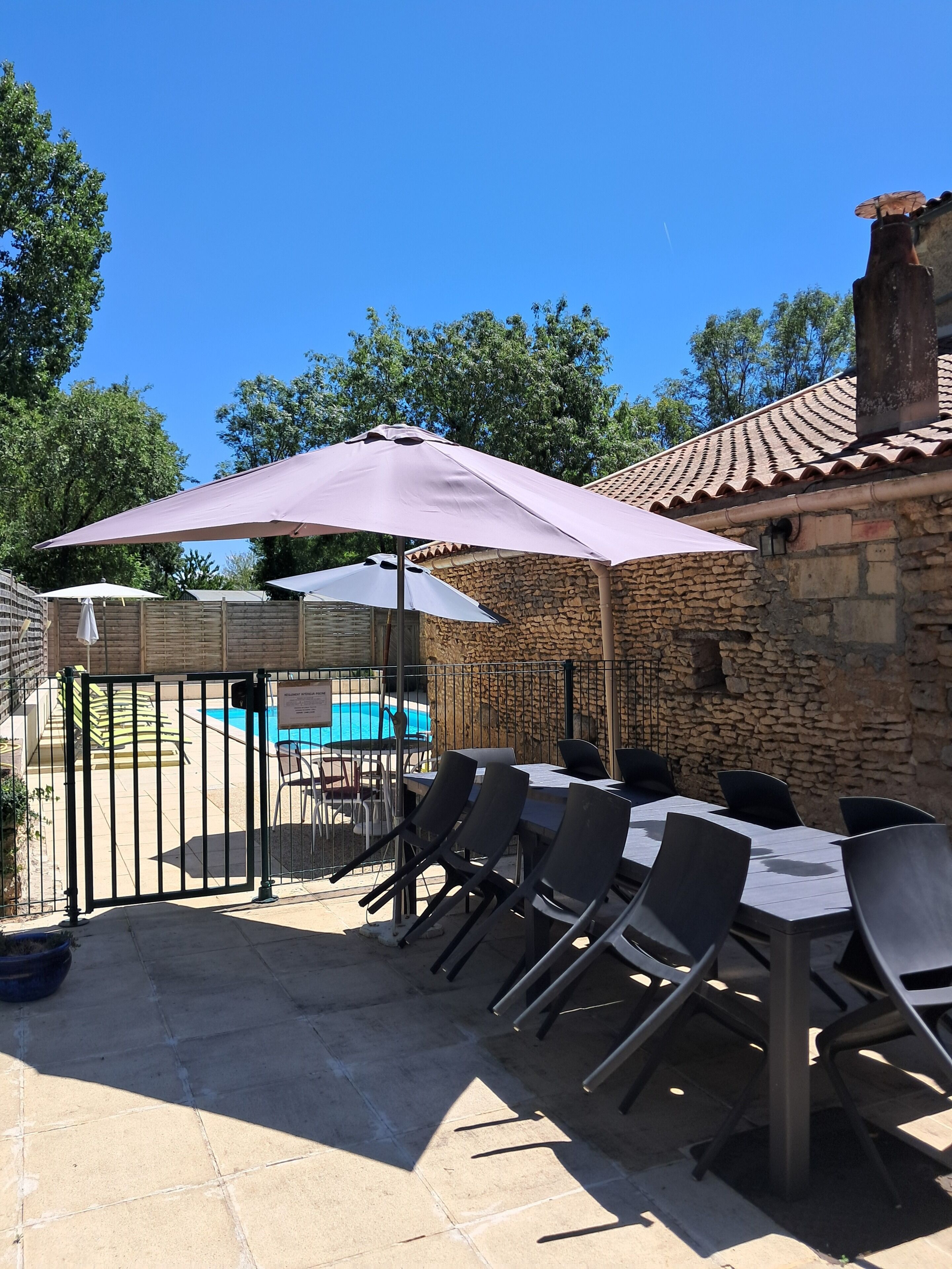 Eine Außenpatio mit Pool, Steinmauern und Sitzgelegenheiten.