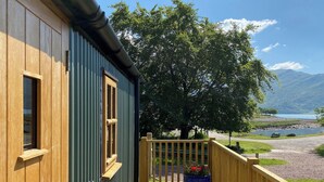 En træterrasse med udsigt over en sø og bjerge.