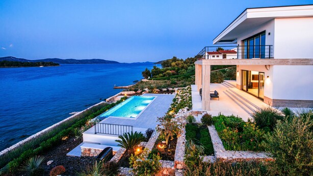 A modern house with a swimming pool, overlooking a large body of water and hills. - Villas Anita (Zadar)