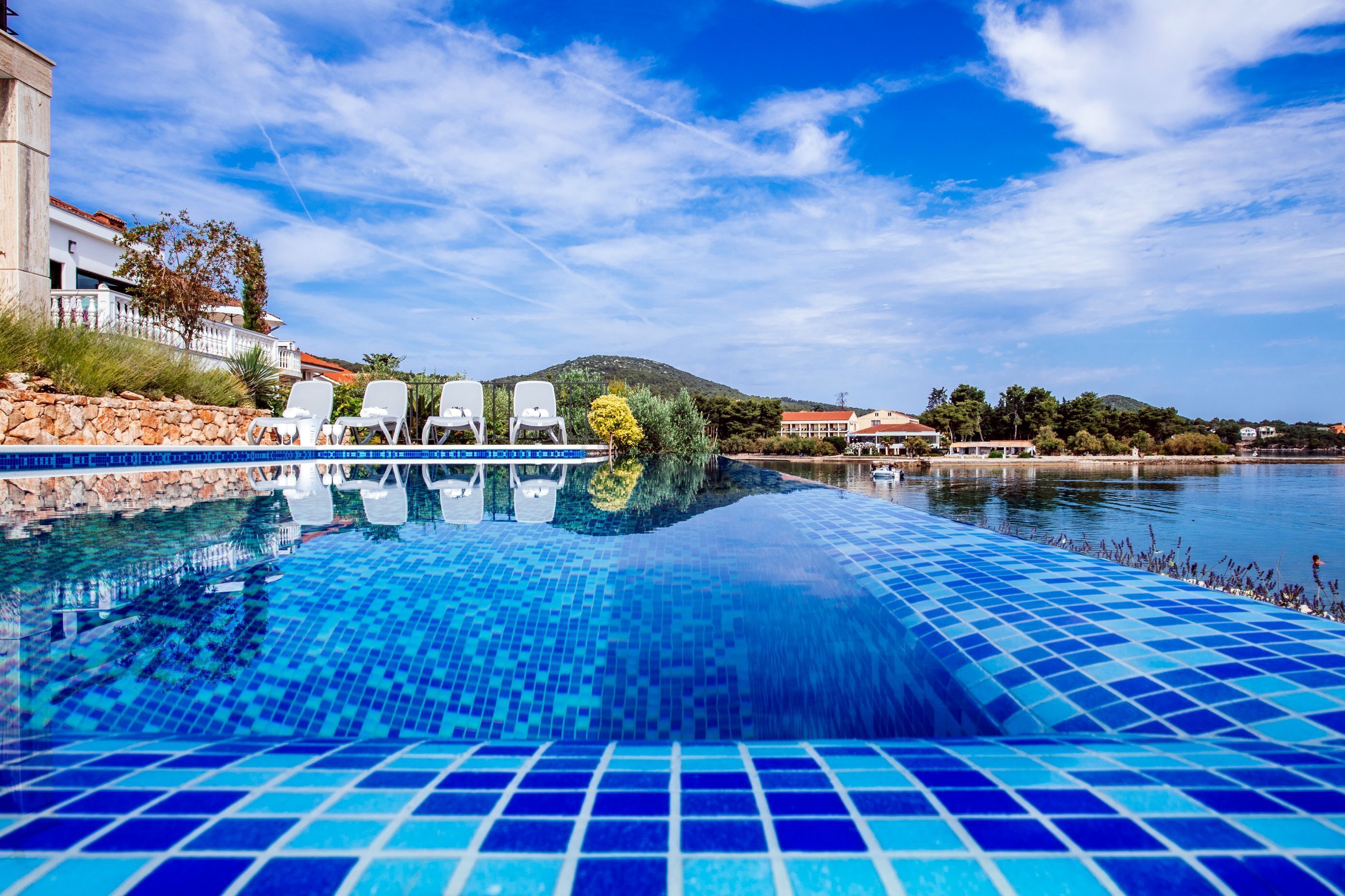 Una piscina al aire libre de temporada, sombrillas, tumbonas