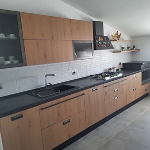 Frigorífico, placa de cocina, cafetera o tetera y utensilios de cocina