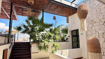 Un interior moderno con una escalera, techo de vidrio y pared de piedra.