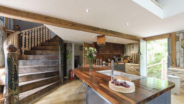 A modern kitchen with a wooden island, a built-in stove, and a large window overlooking a garden. - 4 bedroom accommodation in Longhope, near Gloucester (Longhope, near Gloucester)