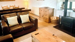 Uma sala de estar com um sofá de couro, um armário de madeira e uma lareira.