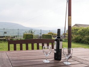 A wooden table with a wine bottle and two wine glasses.