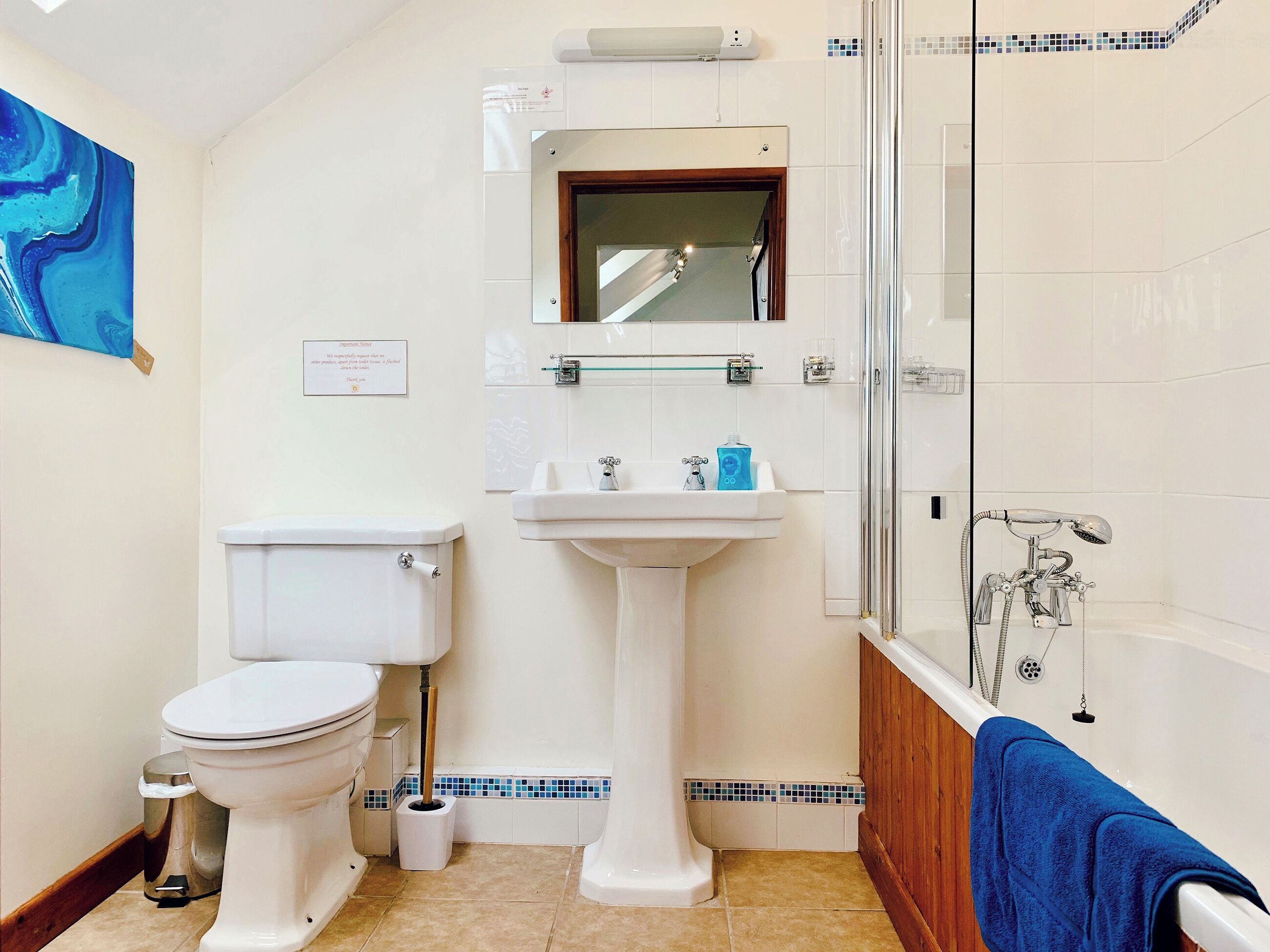 Une salle de bain avec des toilettes, un lavabo et une douche.