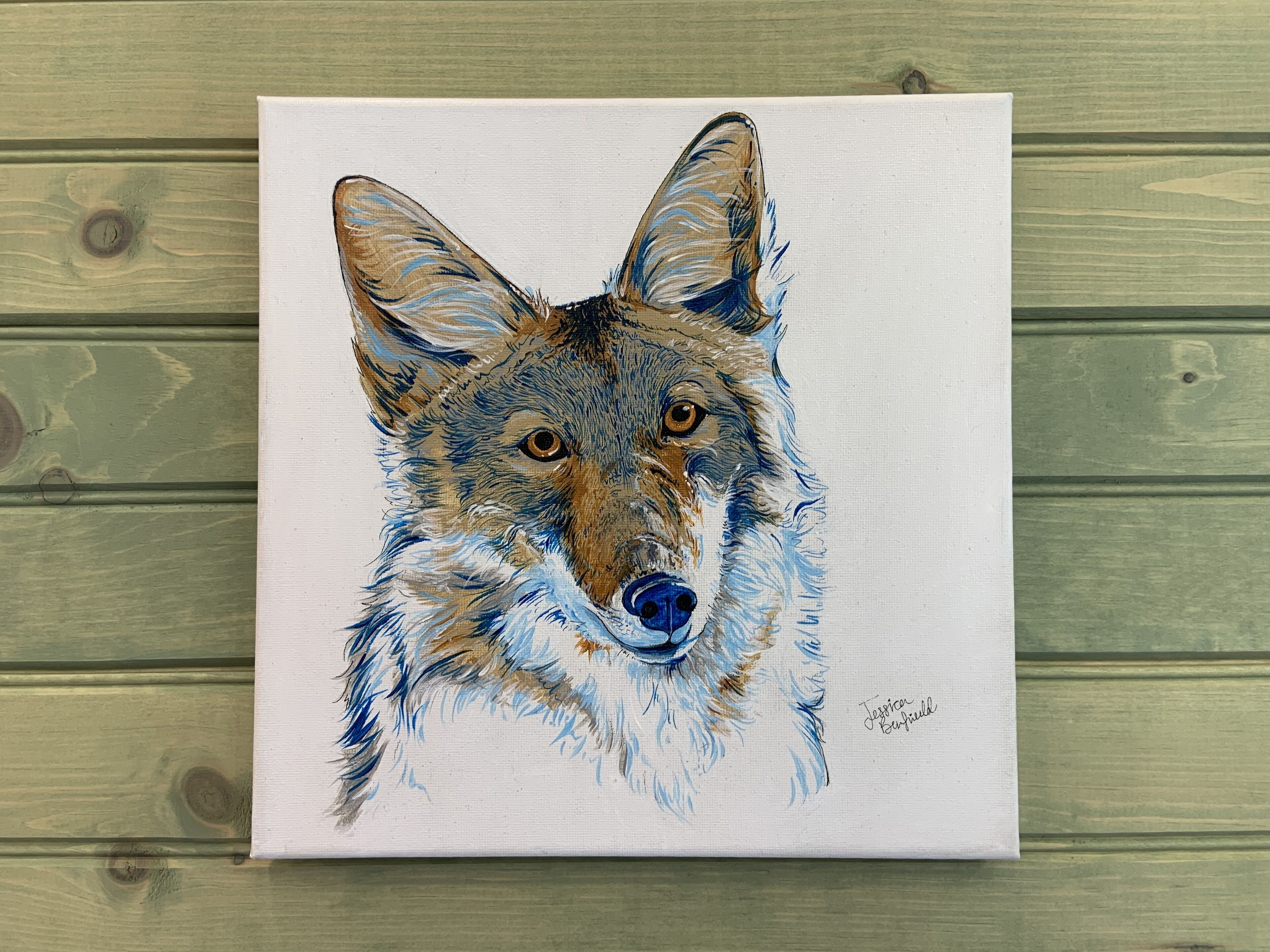 Une peinture représentant la tête d’un loup sur une toile blanche.