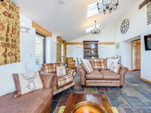 A spacious living area with a fireplace, a large wooden cabinet, and a dining table.