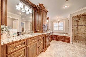 A spacious bathroom with a large vanity, a walk-in shower, and a bathtub.