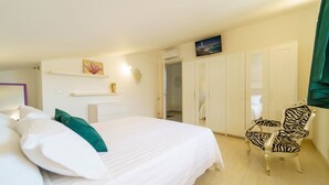 A hotel room with a bed, a zebra-patterned chair, a wardrobe, and a painting on the wall. - Villa Vittoria - Waterfront house (Augusta)