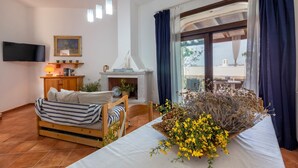 Un dormitorio con cama, televisor, chimenea y vistas al exterior.