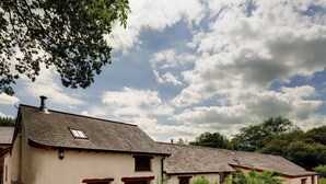 Une maison traditionnelle avec un toit en pente, une cheminée et une petite fenêtre.