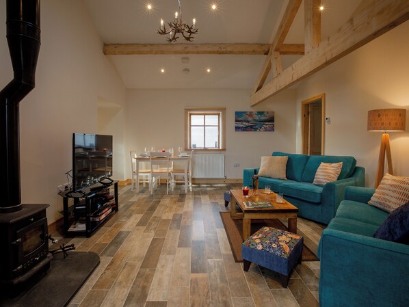 Una sala de estar con chimenea, un sofá, una mesa de centro y un televisor.