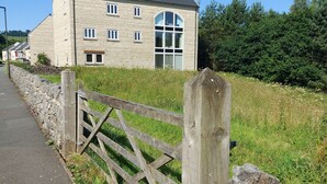 Un edificio de piedra con un gran ventanal arqueado y una puerta de madera.