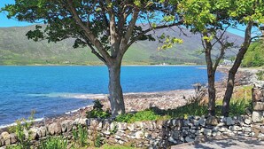 Vista de un lago con muro de piedra y muelle de madera.