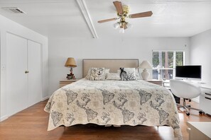 A bedroom with a bed, a desk, a chair, a television, and a window. - Paradise on main canal with spectacular sunset (Key Largo)