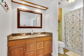 A bathroom with a double sink vanity, a large mirror, and a shower curtain with a paisley pattern. - Paradise on main canal with spectacular sunset (Key Largo)