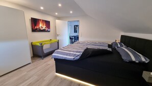 Une chambre à coucher moderne avec un lit, un bureau et un tableau représentant une cheminée.
