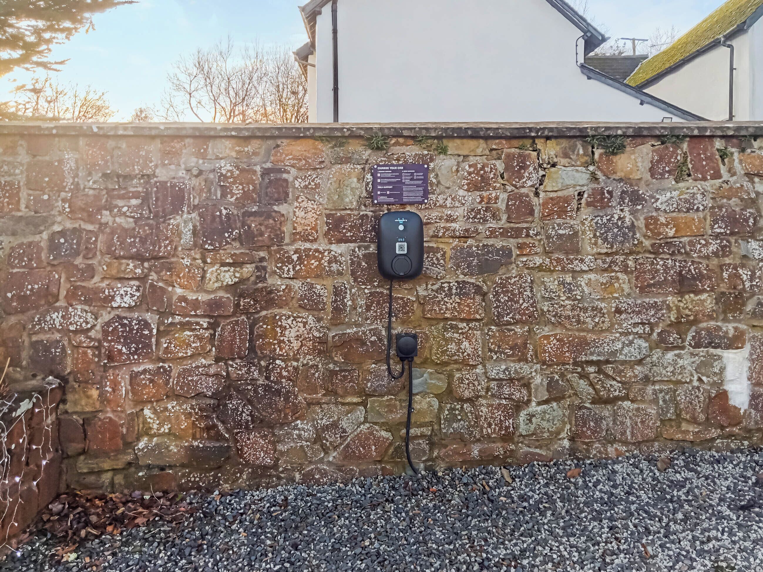 A stone wall with a QR code and a charging station.