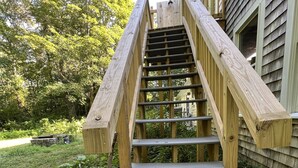 Eine Holztreppe führt zu einem Haus mit einer Betonpodest.