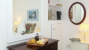 A room with a large mirror, a wooden dresser, a tray with breakfast items, and a lamp. - 1 bedroom accommodation in Frant, Tunbridge Wells (Frant, Tunbridge Wells)