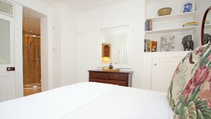 A bedroom with a bed, a dresser, a mirror, and a shower. - 1 bedroom accommodation in Frant, Tunbridge Wells (Frant, Tunbridge Wells)