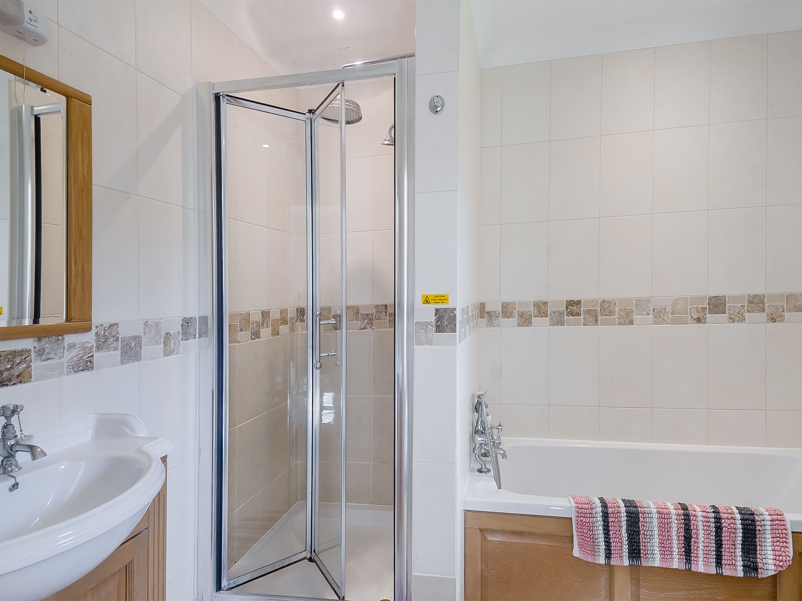 Une salle de bain avec une douche à parois de verre, un lavabo et une baignoire.