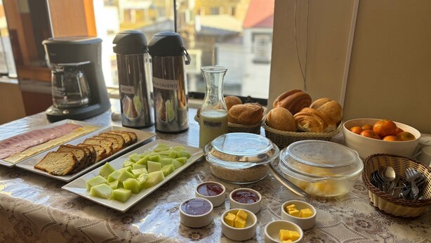 Un bufé de desayuno con diversos alimentos, como pan, frutas y salsas.