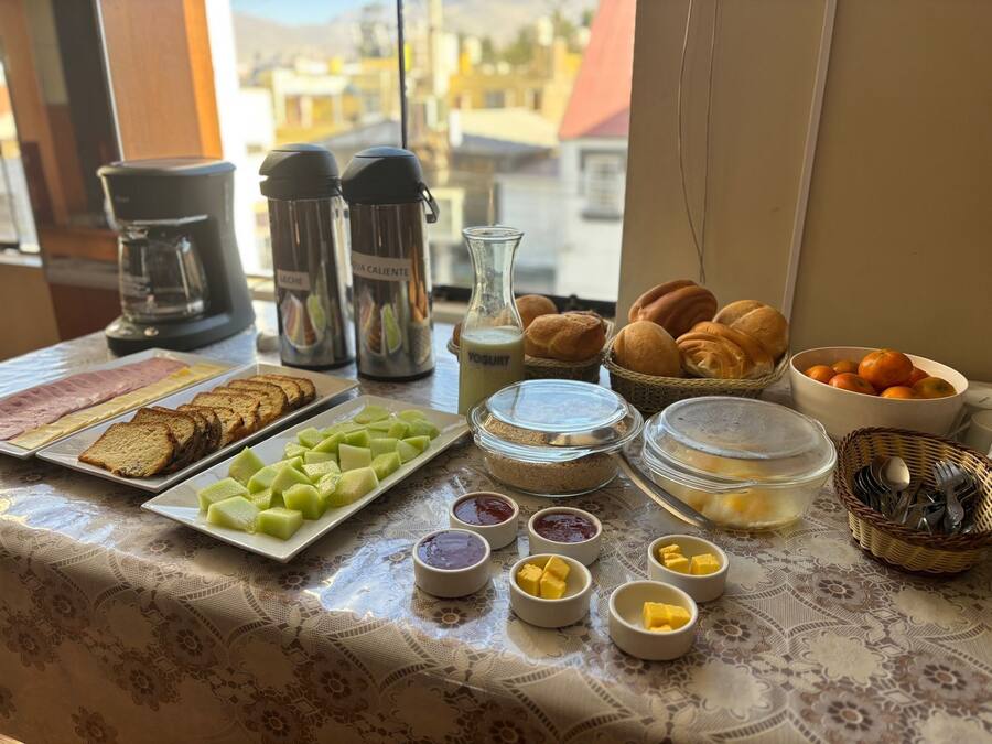 Un bufé de desayuno con diversos alimentos, como pan, frutas y salsas.