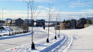 Eine schneebedeckte Straße führt zu einem Schild für Oakland Park.