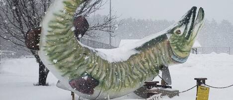 En stor fiskeskulptur i et snæverkoldt udendørs miljø.