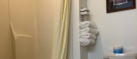 A bathroom with a bathtub, toilet, and a shower curtain.