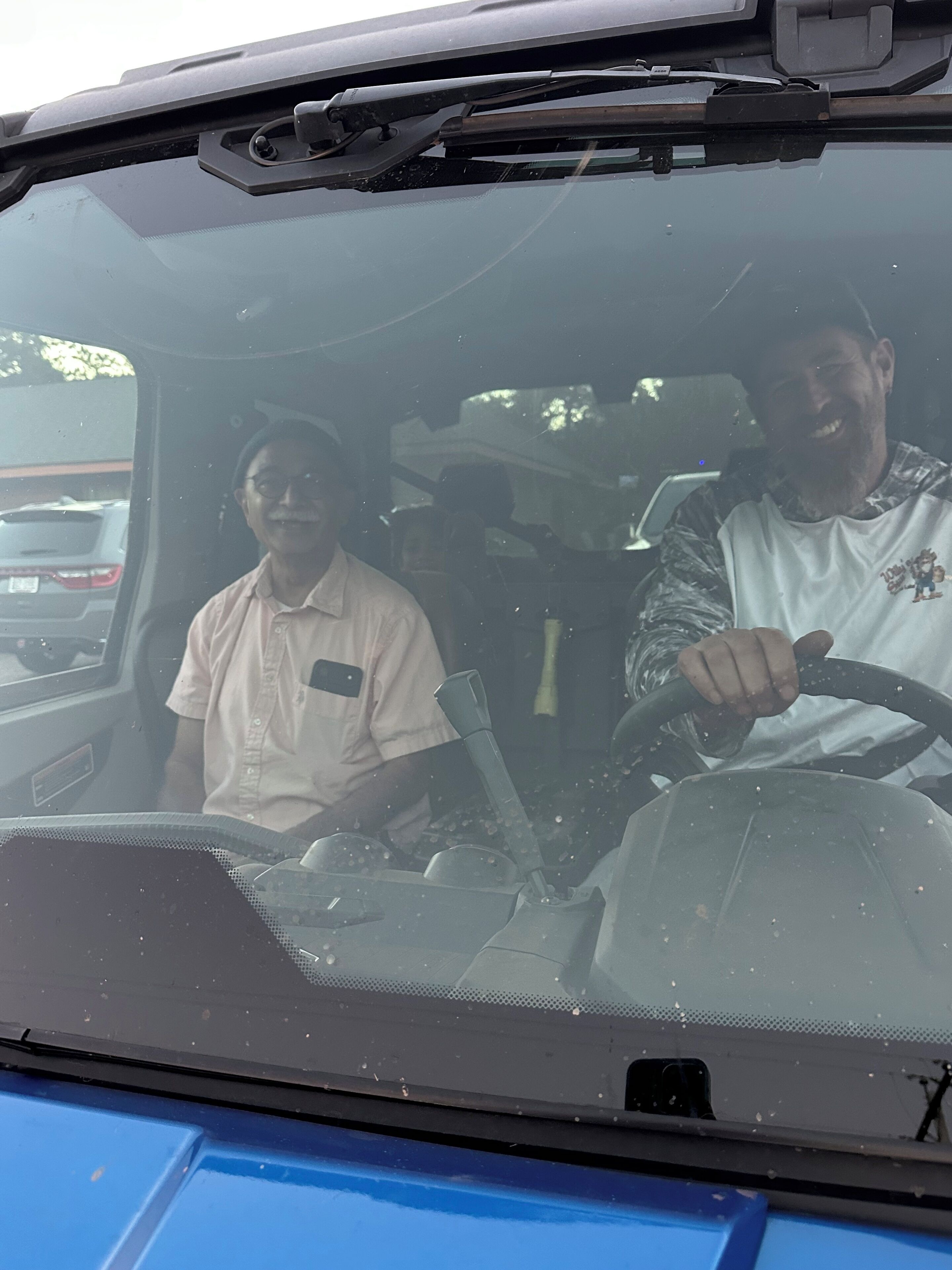 A vehicle interior with two people, one driving and one passenger.