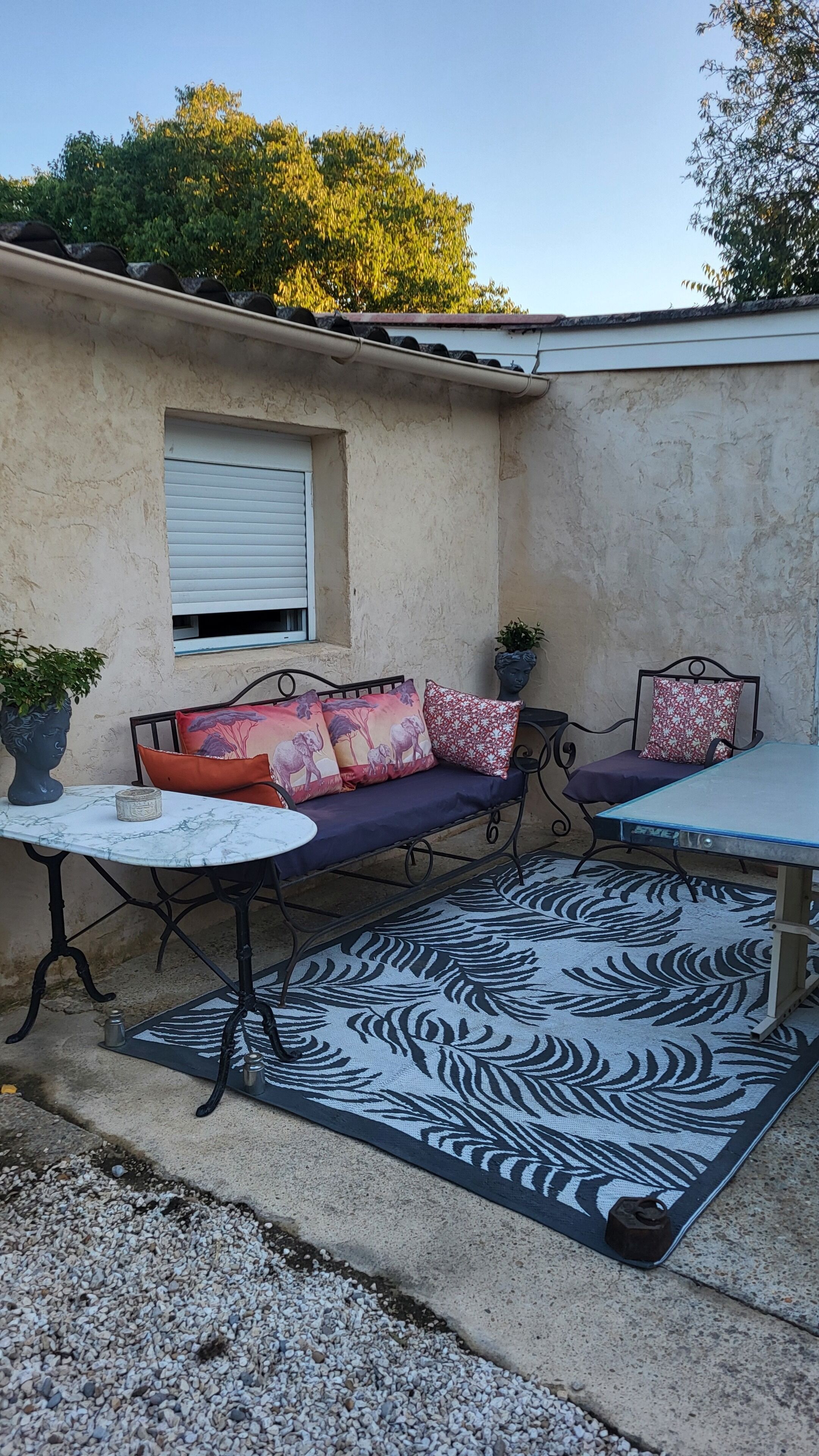 A patio area with a sofa, a small table, and a bench.
