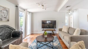 Ein Wohnzimmer mit einer Couch, einem Couchtisch, einem Fernseher und einem Buddha-Gemälde.