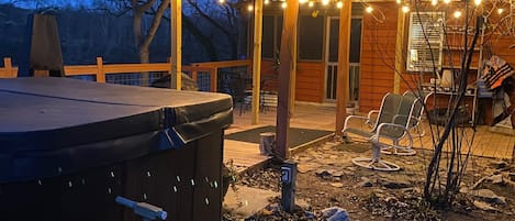 Ein Whirlpool und Sitzbereich im Freien mit Lichterketten.