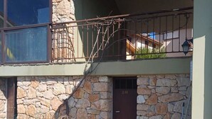 Ein Steinhaus mit einem Balkon, einer Tür mit der Aufschrift „2M“ und einem Metallgitter.