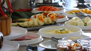 Un buffet proposant une variété de plats, notamment des fruits, des légumes et des viandes.