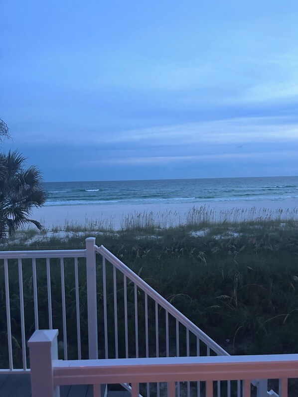 A view of the ocean from a balcony with a railing.